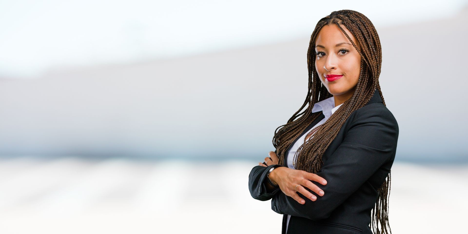 Portrait of a young black business woman crossing his arms, smiling and happy, being confident and friendly